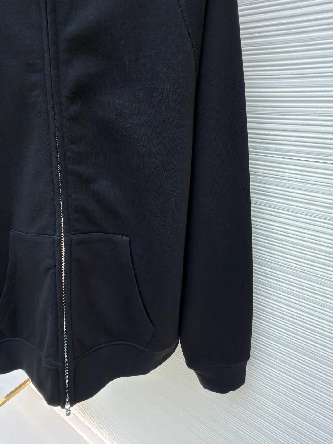 Chrome Hearts solid color hooded embroidered letter sweatshirt ●Original version: purchased and developed by 22939 ●Item number: 1682378-B15 ●Fabric: combed cotton fabric ●Technology: embroidery production ●Color: black ●Version: loose fit ●Weight: about 885 grams ●Size: S-M-L ●Description: This Crow Heart solid color hooded embroidered sweatshirt is made of 420g heavyweight pure cotton terry fabric. It has been processed by enzyme washing process. The fabric is soft and skin-friendly and not easy to deform and pill. It is also pre-shrunk and the size is stable after washing. The body is designed with raglan sleeves, which is ergonomically designed and allows movement without any restriction. The hooded part has a built-in double-layer drawstring, and the rope head is made of metal, which is thick and wear-resistant. The front placket uses a YKK customized zipper, which is smooth and easy to pull and has strong oxidation resistance. The letter logo on the chest adopts imported embroidery technology, using high-gloss embroidery thread, with a stitch density of 15 stitches/cm, and the pattern is three-dimensional and clear without skipping lines. The kangaroo pocket is cut in one piece, and the edges are reinforced with double-needle stitching. The ribbed fabric on the cuffs and hem is custom-woven and high-elastic, which will not loosen after long-term wear. The overall seams are combined with flat stitching and overlocking. The details show the brand's hard-core craftsmanship and street style. The overall wiring is straight and delicate, the fabric is comfortable and soft, and the color is consistent without color difference. It can be matched with the same style to create a fashionable look and control various occasions. Customized accessories, complete with three standards, same style for men and women!
